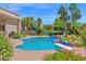 Inviting backyard pool with diving board, rock features, and landscaping, set against the backdrop of palm trees at 1940 N Stevens Cir, Mesa, AZ 85205
