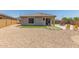 Backyard featuring a gravel area, dining set on the patio, and artificial turf accents at 20109 W Madison St, Buckeye, AZ 85326