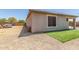 View of the backyard with gravel, grass, a small patio, and the home's exterior at 20109 W Madison St, Buckeye, AZ 85326