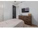 Comfortable bedroom showcasing a wood dresser, TV, and a view to the ensuite at 20109 W Madison St, Buckeye, AZ 85326