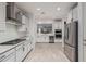 Modern kitchen features stainless steel appliances, granite countertops, sleek white cabinetry, and an open concept layout at 20109 W Madison St, Buckeye, AZ 85326