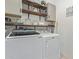 Functional laundry room equipped with modern washer and dryer, plus ample shelving at 20109 W Madison St, Buckeye, AZ 85326