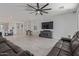 Open-concept living room with expansive tile flooring, stylish furniture, and a large TV at 20109 W Madison St, Buckeye, AZ 85326