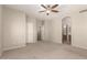 Bedroom with neutral walls, carpet flooring, and an arched doorway to an ensuite bathroom at 20632 N 103Rd Ave, Peoria, AZ 85382