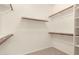Walk-in closet with ample shelving and wooden rods for storage at 20632 N 103Rd Ave, Peoria, AZ 85382