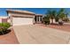 Charming single-story home features a two-car garage, desert landscaping, and a beige exterior at 20632 N 103Rd Ave, Peoria, AZ 85382