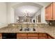 Kitchen view shows granite countertops, stainless steel sink, with an open view to the living room at 20632 N 103Rd Ave, Peoria, AZ 85382