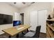 Bright home office features neutral walls, modern desk setup, and closet storage for a comfortable workspace at 20632 N 103Rd Ave, Peoria, AZ 85382