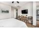 Bedroom features a TV, woven storage baskets, and neutral walls with white trim and light-colored hardwood floors at 2090 S Dorsey Ln # 1019, Tempe, AZ 85282