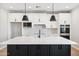 Modern kitchen featuring a large island with a white countertop, black cabinets, and pendant lighting at 2249 N Shannon Way, Mesa, AZ 85215