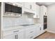 Contemporary kitchen with white cabinets, stainless steel appliances, stylish backsplash, and sleek countertops at 2249 N Shannon Way, Mesa, AZ 85215