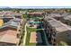 Aerial view of a community featuring a sand volleyball court, playground, and a sparkling blue swimming pool at 240 W Juniper Ave # 1020, Gilbert, AZ 85233