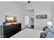 This bedroom has a neutral color scheme and TV sitting on a dresser with an adjoined bathroom at 240 W Juniper Ave # 1020, Gilbert, AZ 85233