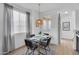 Well-lit dining area features a glass table, modern chairs, and a unique woven light fixture at 240 W Juniper Ave # 1020, Gilbert, AZ 85233