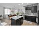 Open concept kitchen with island, black cabinetry with gold hardware, stainless steel appliances, and geometric backsplash at 240 W Juniper Ave # 1020, Gilbert, AZ 85233