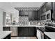 Modern kitchen features black cabinets, geometric backsplash, stainless steel appliances, and quartz countertops at 240 W Juniper Ave # 1020, Gilbert, AZ 85233