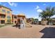 Community playground featuring modern play structures and shaded seating areas against a backdrop of attractive townhomes at 240 W Juniper Ave # 1020, Gilbert, AZ 85233