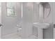 Bathroom featuring a pedestal sink, round mirror, toilet, and window with natural light at 2625 S Peppertree Dr # 101, Gilbert, AZ 85295