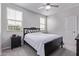 A simple bedroom with a queen-sized bed, a ceiling fan, and a dark wood nightstand at 2625 S Peppertree Dr # 101, Gilbert, AZ 85295