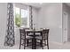 A stylish dining area with a table for four, grey chairs, and a large window with patterned curtains at 2625 S Peppertree Dr # 101, Gilbert, AZ 85295