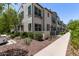 View of a townhome featuring multiple windows, landscaping, and a sidewalk at 2625 S Peppertree Dr # 101, Gilbert, AZ 85295
