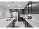 Modern kitchen featuring dark cabinets, stainless steel appliances, and a large island with quartz countertops at 2625 S Peppertree Dr # 101, Gilbert, AZ 85295