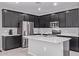 This kitchen features dark wood cabinetry, stainless appliances and a kitchen island with a double sink at 2625 S Peppertree Dr # 101, Gilbert, AZ 85295