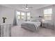 Bright main bedroom with a ceiling fan, two windows, neutral walls, and a wooden bed frame at 2625 S Peppertree Dr # 101, Gilbert, AZ 85295
