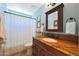Bathroom showcases warm wood vanity with marble countertop, and shower-tub combination at 26647 N 43Rd N St, Cave Creek, AZ 85331