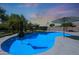 Sparkling pool with underwater lights, complemented by a landscaped backyard with umbrellas and a basketball hoop at 26647 N 43Rd N St, Cave Creek, AZ 85331