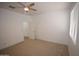 Spacious bedroom features neutral carpet, ceiling fan, and a door that opens to an ensuite bathroom at 28377 N Desert Native St, San Tan Valley, AZ 85143