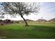 Scenic golf course with lush green fairways, flags, trees, and mountain views providing a picturesque landscape at 28377 N Desert Native St, San Tan Valley, AZ 85143