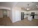 Kitchen is open to the living room, stainless appliances, white cabinets, and quartz countertops at 28377 N Desert Native St, San Tan Valley, AZ 85143