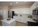 Well-lit kitchen featuring white cabinetry, stainless steel appliances, and a stylish island with quartz counters at 28377 N Desert Native St, San Tan Valley, AZ 85143