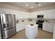 Bright kitchen with white cabinets, stainless steel appliances, granite countertops, and a center island at 28377 N Desert Native St, San Tan Valley, AZ 85143