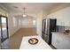 Open-concept kitchen featuring stainless steel appliances, white cabinetry and an island open to the dining area at 28377 N Desert Native St, San Tan Valley, AZ 85143