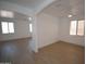 Open living room with modern wood-look floors and lots of natural light from the many windows at 28377 N Desert Native St, San Tan Valley, AZ 85143