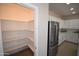 Walk-in pantry with ample shelving next to stainless steel fridge and kitchen with white cabinets at 28377 N Desert Native St, San Tan Valley, AZ 85143