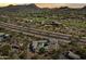 Aerial view showing the house with a pool, along with other houses in a golf community, with surrounding mountains at 28729 N 107Th St, Scottsdale, AZ 85262