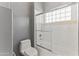 Bright bathroom featuring a white tub with glass doors and a window with glass blocks at 28729 N 107Th St, Scottsdale, AZ 85262
