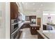 Gourmet kitchen featuring sleek, dark wood cabinetry, stainless steel appliances, and a functional island at 28729 N 107Th St, Scottsdale, AZ 85262