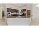 Bright kitchen with stainless steel appliances, dark wood cabinets, and a breakfast bar with granite countertops at 28729 N 107Th St, Scottsdale, AZ 85262