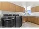 Functional laundry room with cabinetry, modern appliances, and a sink, making chores convenient at 28729 N 107Th St, Scottsdale, AZ 85262