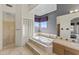 Spa-like bathroom boasts a luxurious tub, glass block window, and tiled shower at 28729 N 107Th St, Scottsdale, AZ 85262