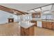 Open-concept kitchen with island, wood cabinets, fireplace, and adjacent dining area at 3046 E Dover St, Mesa, AZ 85213