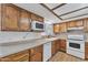 Cozy kitchen featuring wood cabinets, brick backsplash, and modern appliances for cooking at 3046 E Dover St, Mesa, AZ 85213