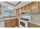 Charming kitchen with wood cabinets, a double sink, and essential appliances at 3046 E Dover St, Mesa, AZ 85213