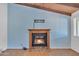 Cozy living room featuring a fireplace, blue accent wall, and wood beamed ceilings at 3046 E Dover St, Mesa, AZ 85213