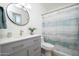 Bathroom with updated vanity with brushed gold hardware, circular mirror, and modern fixtures at 3307 W Mescal St, Phoenix, AZ 85029