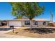 Charming single-story home featuring an attached two-car garage and mature tree in the front yard at 3307 W Mescal St, Phoenix, AZ 85029